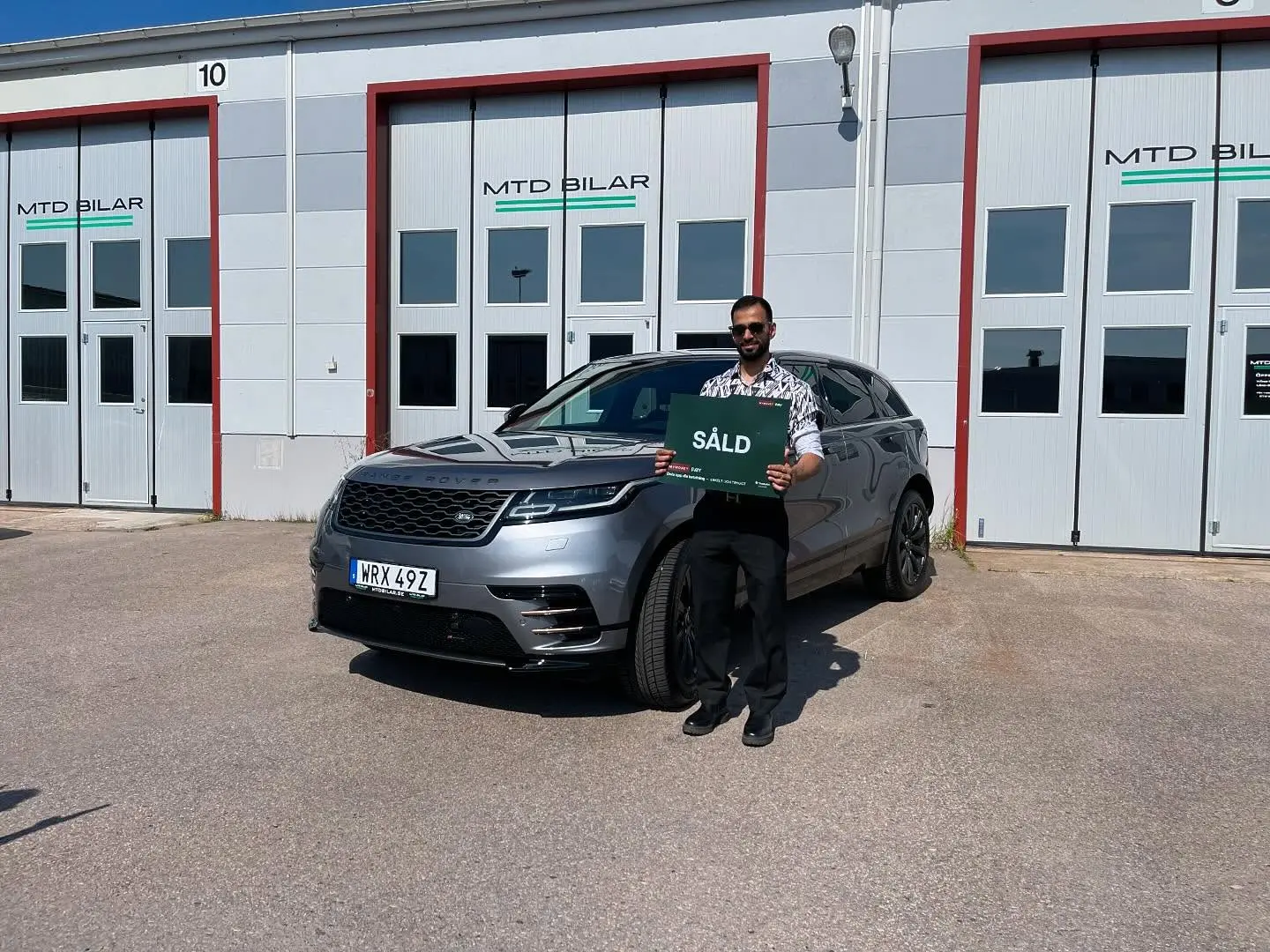 Kund vid leverans av grå Range Rover utanför MTD Bilar i Kalmar.
